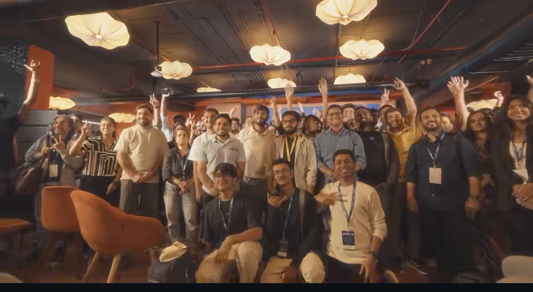 VibeCon closing group photo — hands up, packed room.